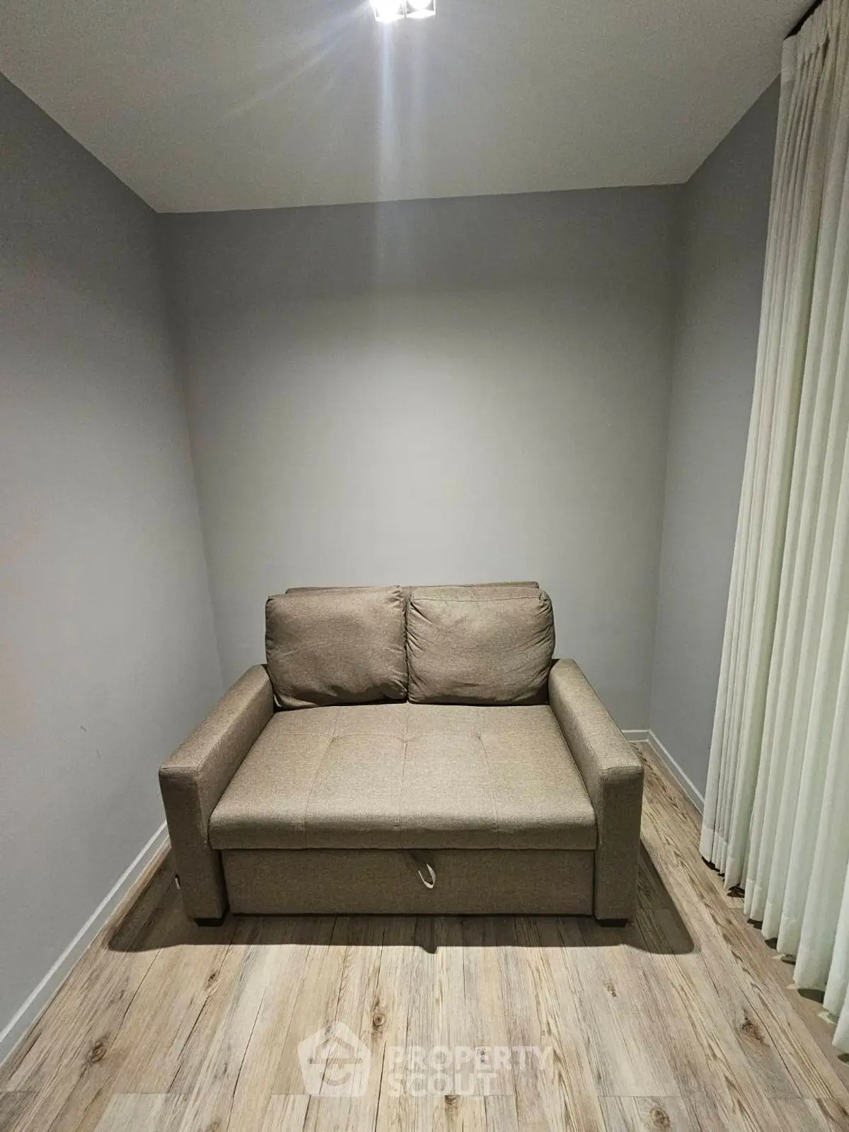 Cozy small living room with a compact sofa and elegant curtains.
