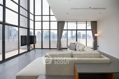 Spacious modern living room with floor-to-ceiling windows and stunning city view.
