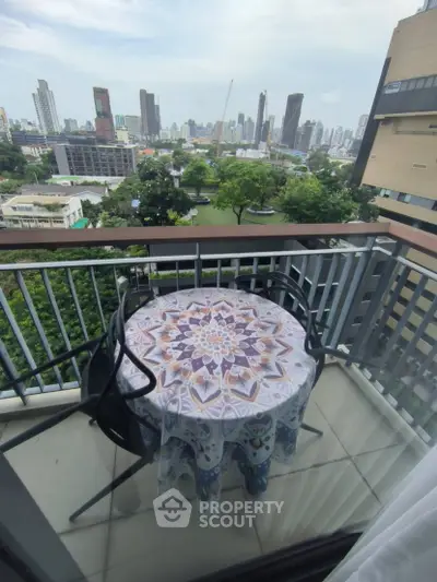 Charming balcony with cityscape view, featuring a decorative table and chairs, perfect for relaxation.