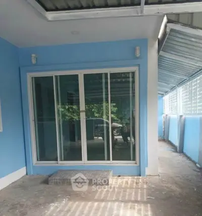 Charming blue exterior with sliding glass doors and covered walkway, perfect for modern living.