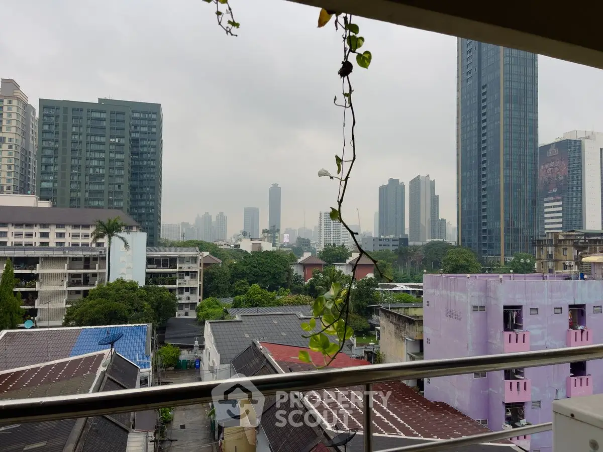 Stunning cityscape view from a balcony overlooking urban skyline and greenery.