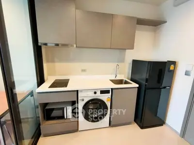 Modern compact kitchen with appliances including washing machine and fridge in sleek design.