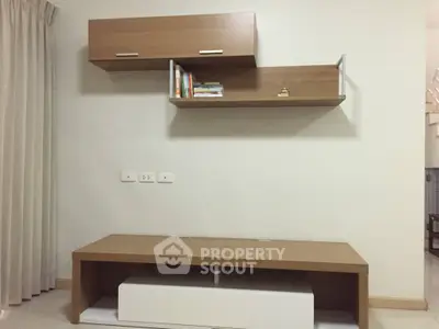 Modern minimalist living room with sleek wooden shelves and cabinets.