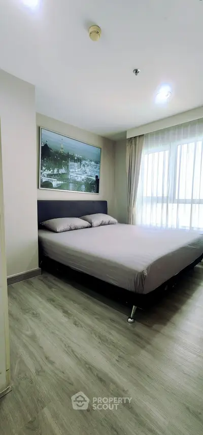 Modern bedroom with stylish decor and large window for natural light