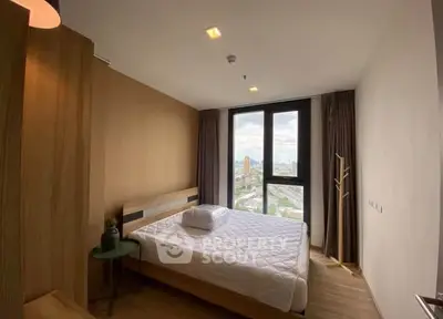 Modern bedroom with large window offering stunning city view, featuring cozy bed and stylish decor.