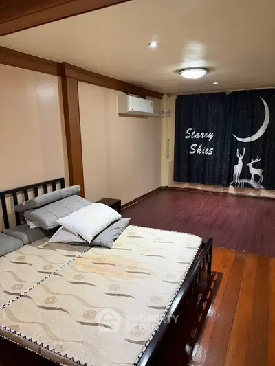 Spacious bedroom with elegant wooden flooring and stylish decor