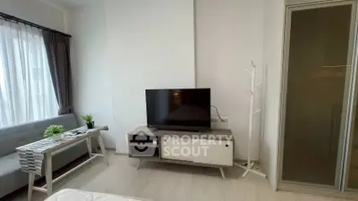 Modern living room with sleek TV stand and cozy seating area, perfect for relaxation.