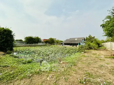 Expansive property with lush greenery and serene pond, ideal for development or tranquil living.