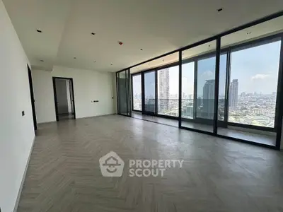 Spacious modern living room with floor-to-ceiling windows and stunning city view.