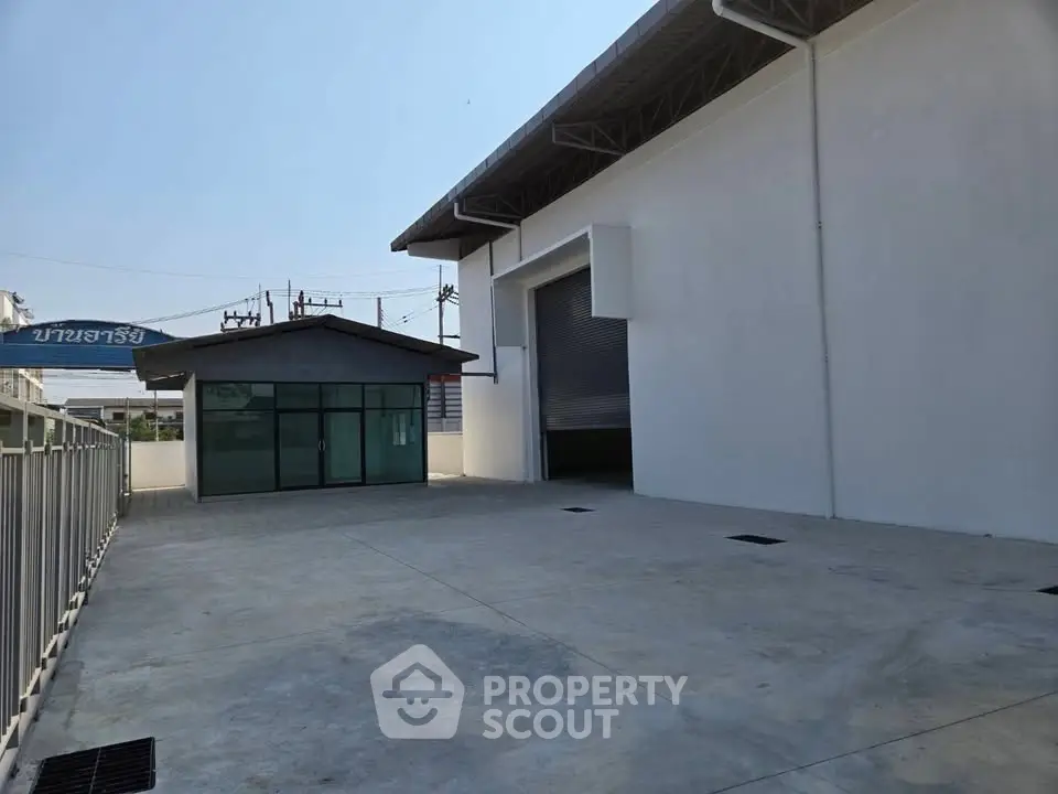 Spacious industrial warehouse with large loading dock and secure gated entrance.