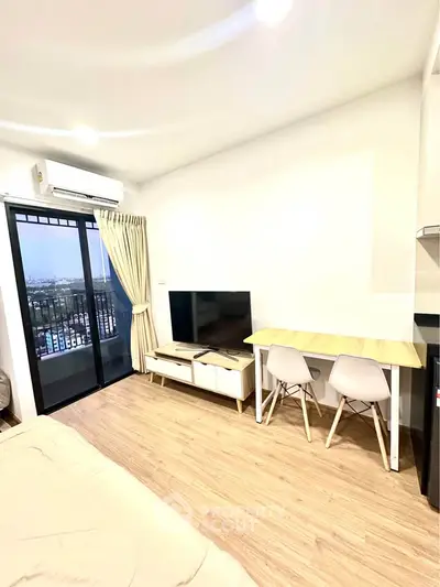 Modern living room with balcony view, featuring sleek furniture and natural light.