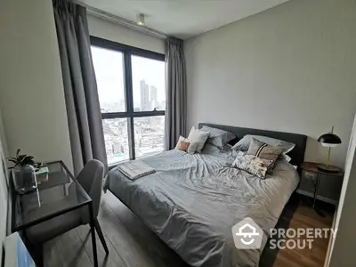 Modern bedroom with city view, featuring stylish decor and large window.