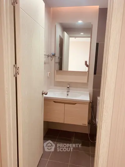 Modern bathroom with sleek vanity and mirror in contemporary apartment.