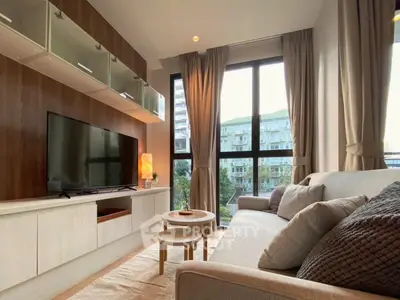 Modern living room with large windows and stylish furniture in a high-rise apartment.
