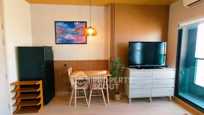 Modern living room with stylish decor, TV, dining area, and balcony access.