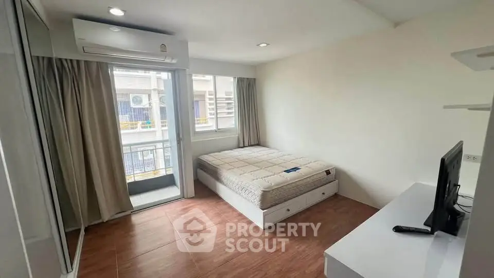Modern bedroom with balcony access and natural light in urban apartment