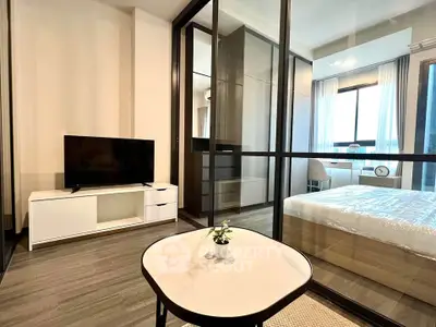 Modern apartment interior with glass partition, featuring a cozy living area and stylish bedroom.