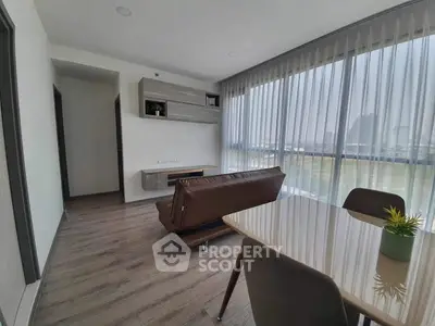 Modern living room with large windows and stylish furniture in a contemporary apartment.