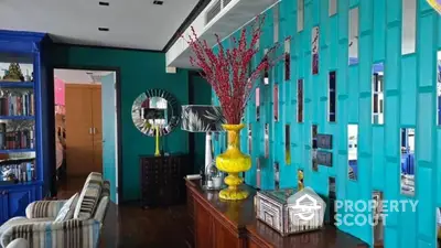 Vibrant living room with teal accent wall and eclectic decor