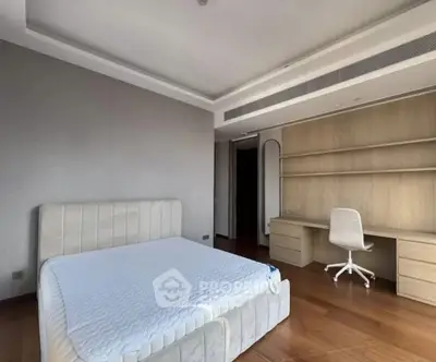 Spacious modern bedroom with elegant design and built-in desk area.