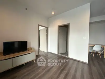 Modern living room with sleek wooden flooring and minimalist furniture design.