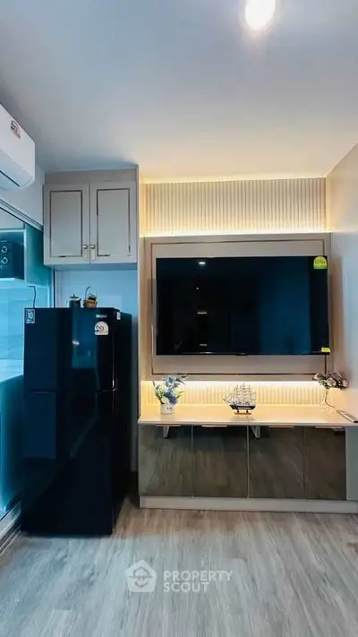 Modern living room with sleek black fridge and stylish TV setup