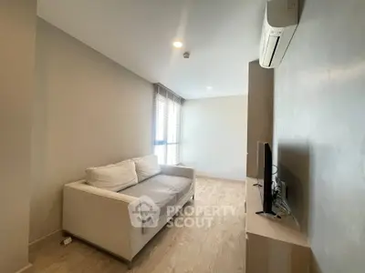 Modern living room with cozy sofa and wall-mounted air conditioner in bright apartment.