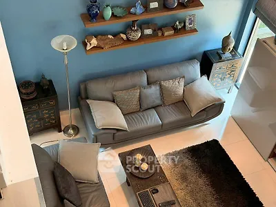 Stylish living room with modern gray sofas, decorative shelves, and elegant decor accents.