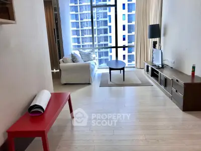Modern living room with large windows and stylish furniture in a high-rise apartment.