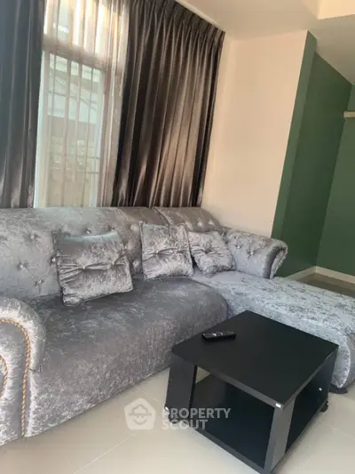 Elegant living room with plush silver sofa and modern black coffee table