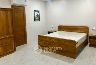 Spacious bedroom with wooden furniture and modern decor in a cozy apartment.