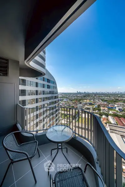 Stunning balcony view from high-rise apartment with modern furniture and cityscape.