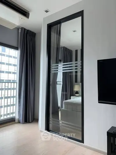Modern bedroom with floor-to-ceiling windows and sleek design in a high-rise apartment.