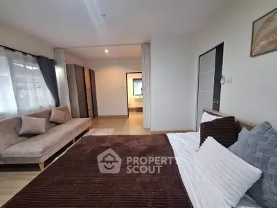 Spacious bedroom with cozy seating area and modern decor