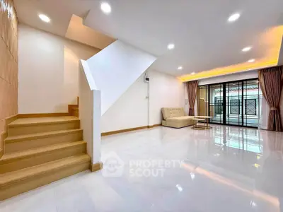 Spacious modern living room with elegant staircase and large windows