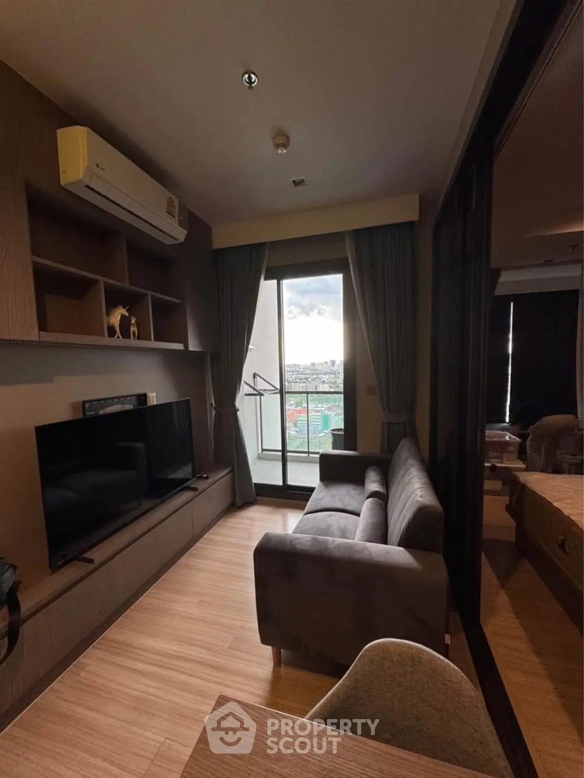 Modern living room with balcony view, featuring sleek furniture and natural light.