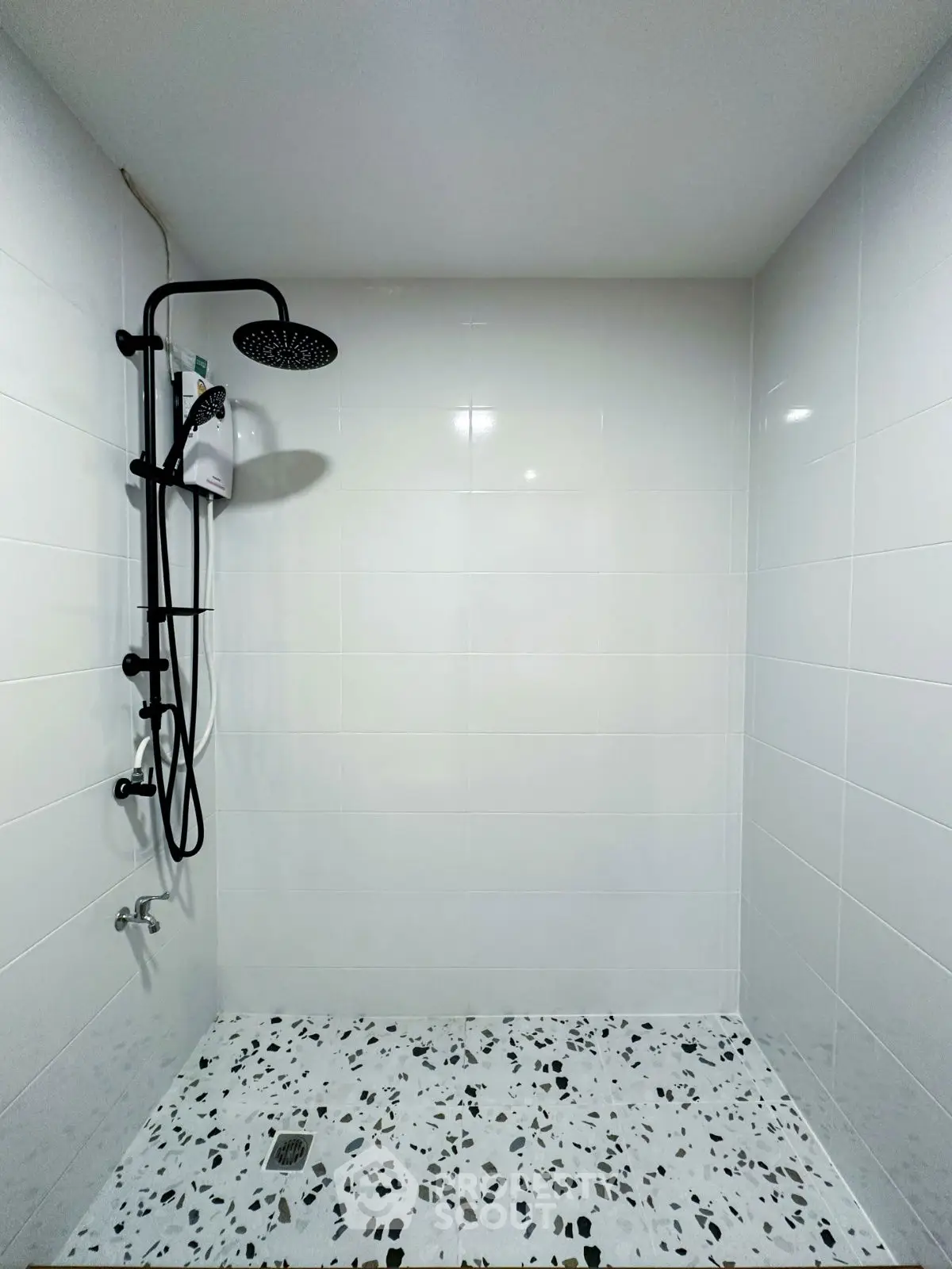Modern minimalist bathroom with sleek shower and terrazzo flooring.