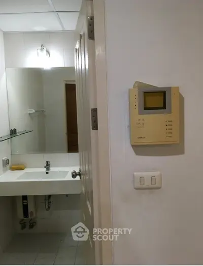Modern bathroom with wall-mounted intercom and sleek sink design