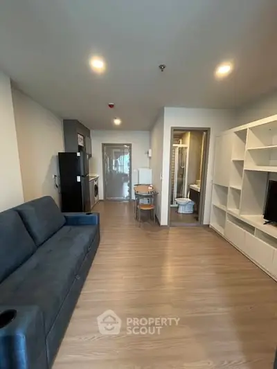 Modern living room with sleek design and open layout, featuring a cozy sofa and stylish shelving.