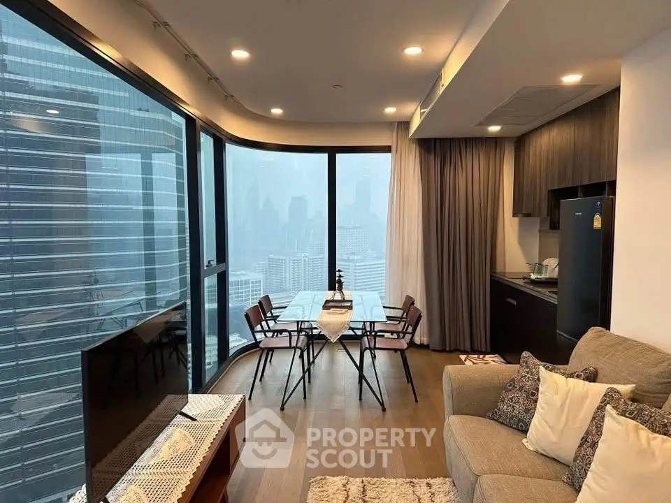 Modern living room with city view, featuring floor-to-ceiling windows and stylish furniture.