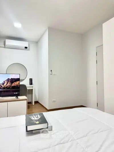 Modern bedroom with sleek design, featuring a TV, air conditioning, and stylish decor.