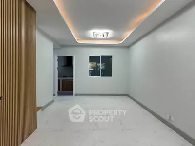 Spacious modern living room with elegant ceiling lighting and sleek flooring