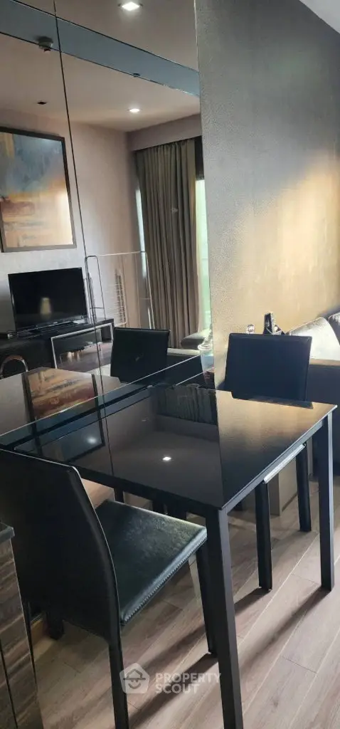 Modern living room with sleek black dining table and mirrored wall, perfect for urban living.
