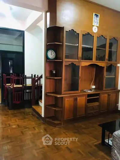 Charming wooden interior with built-in shelving and dining area, perfect for cozy gatherings.