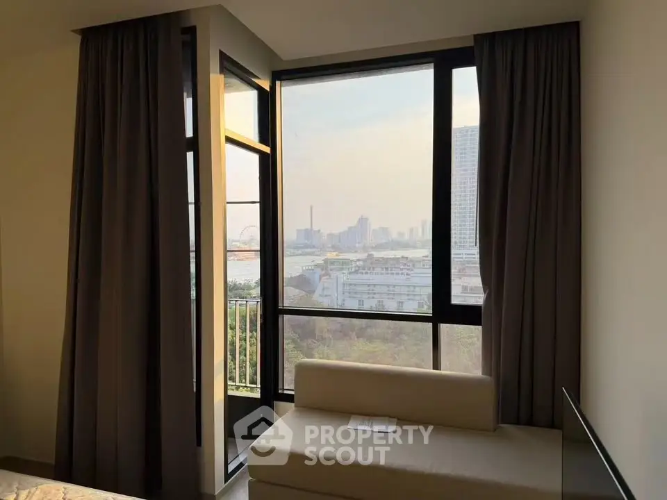 Modern apartment with stunning city view from large windows and cozy seating area.