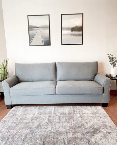 Stylish living room with modern gray sofa and elegant decor, perfect for cozy relaxation.