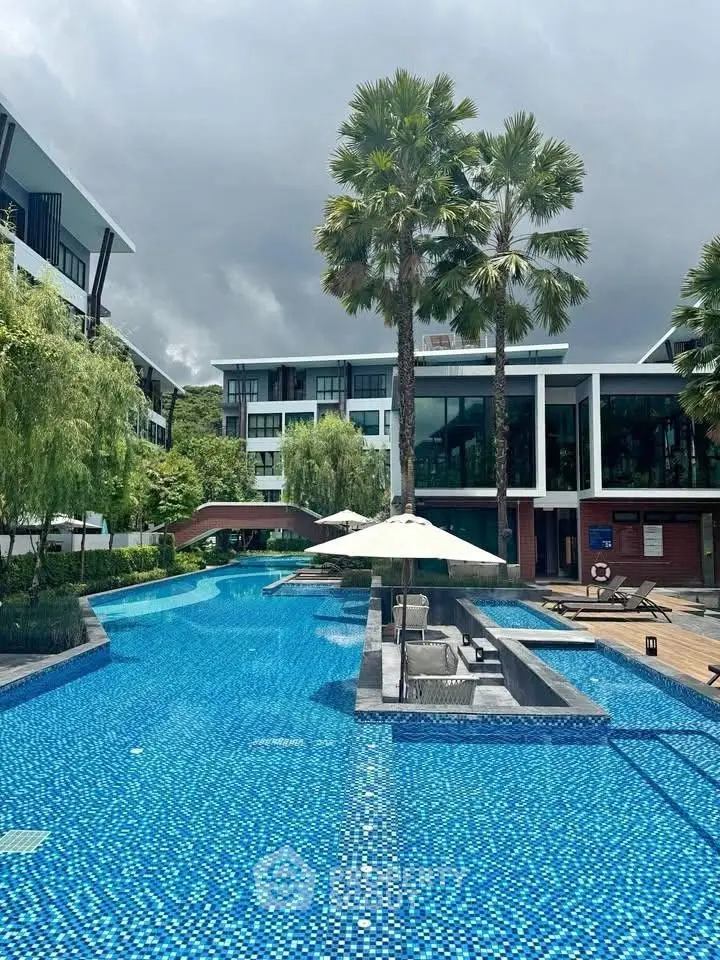 Luxurious residential pool area with modern architecture and lush greenery.