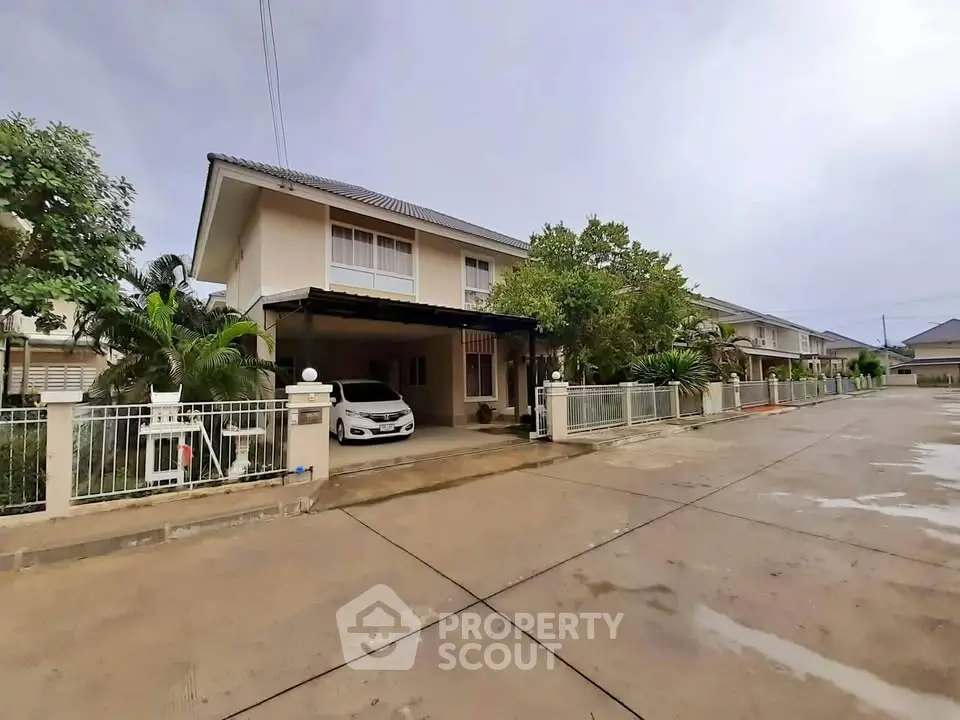 Charming suburban house with driveway and lush greenery in a peaceful neighborhood.