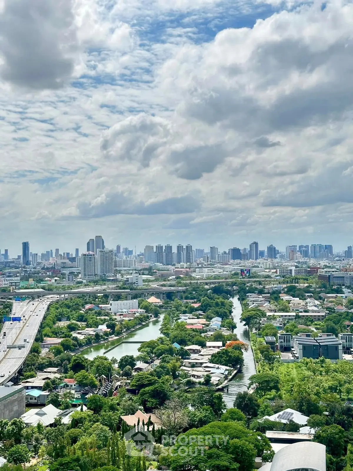 Stunning cityscape view from high-rise building showcasing lush greenery and urban skyline.