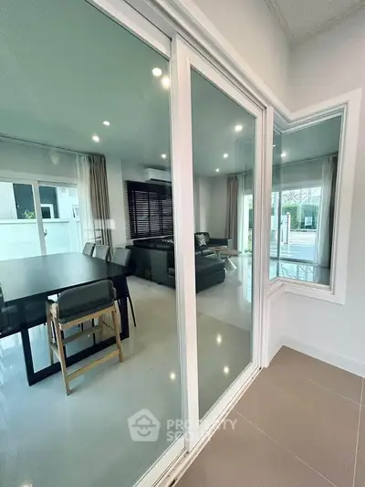 Modern living room with glass sliding doors and elegant dining area